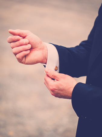 The groom closes the cufflinksの写真素材