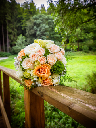 The bridal bouquet on the bridge with pink and orange rosesの写真素材