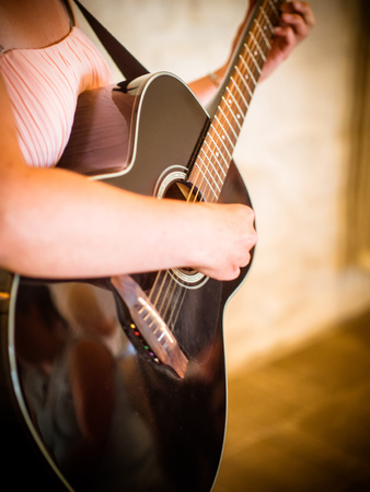 Close up of male arm playing guitar skillfully. Focus on woman fingers touching the strings while doing accordの写真素材