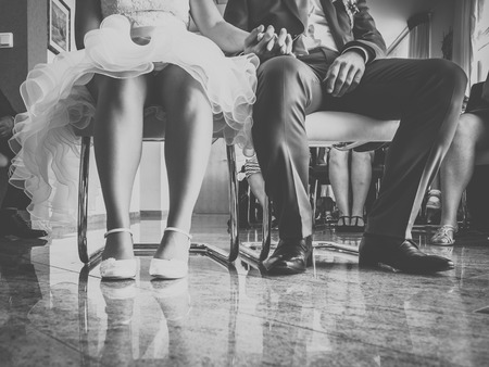 the bride and groom are sitting on the chairの写真素材