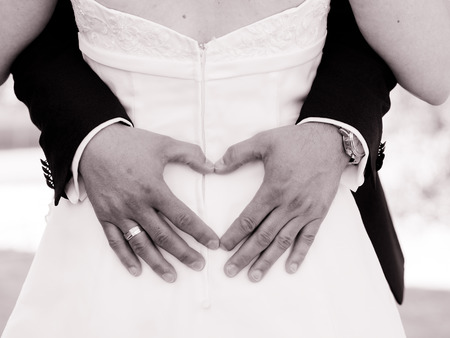the heart on the back, the groom puts a heart on the back of the bride with his handsの写真素材