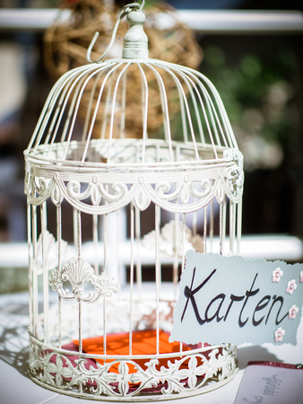 Vintage bird cage at a wedding reception used for decoration and collecting envelopes in colorの写真素材