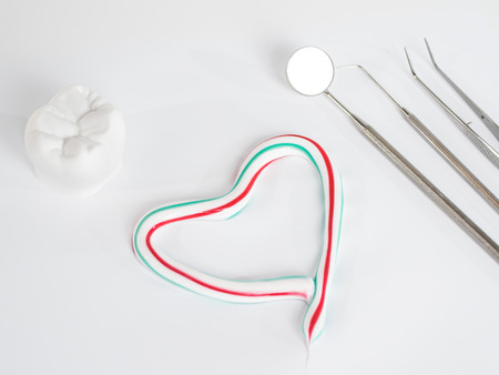 Mirror on a white backgroundand dental care and a heart of toothpaste on a white bachgroundの写真素材