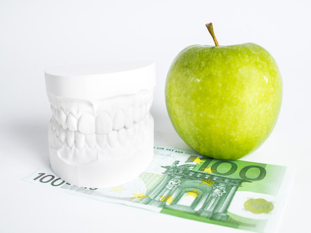 The green apple, the denture and the one hundred euro bill isolatedの写真素材