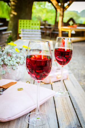 A glass and a bottle of rose in the autumn vineyard. Harvest time, summer time in the garden on the terraceの写真素材