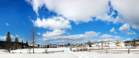 Cloudy sky and snowy plain in the village  Beautiful winter landscapeの写真素材
