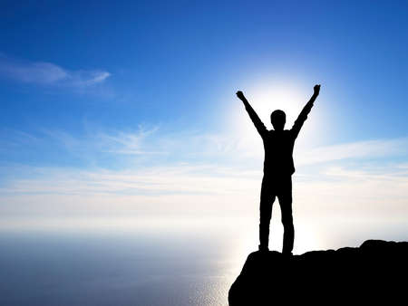 Silhouette of a winner on the mountain top