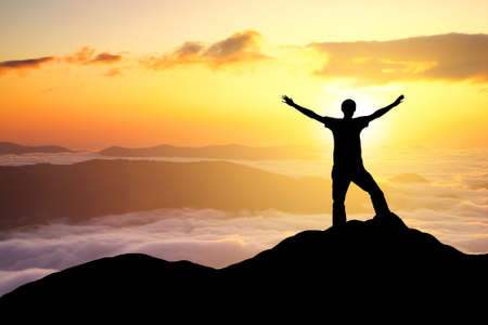 Silhouettes of champion on mountain peak. Sport and active life conceptの写真素材