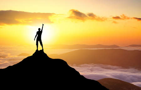 Silhouette of a champion on mountain top. Sport and active life conceptの写真素材