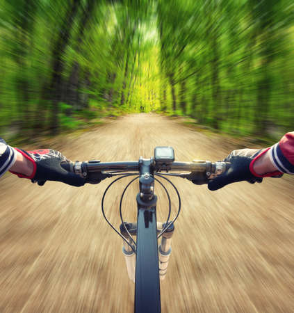 Ride on bicycle on road in summer forest. Sport and active life conceptの写真素材