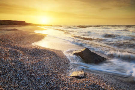 Sea shore during gold sunrise. Beautiful natural seascapeの写真素材