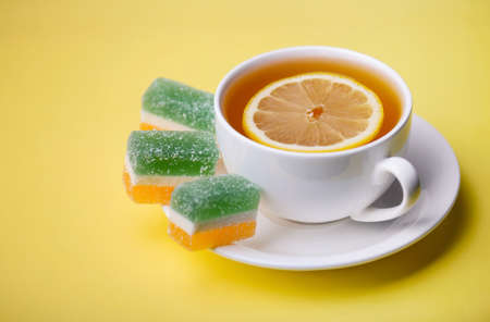 Tea with lemon and fruit jelly. Food and drink as a backgroundの写真素材