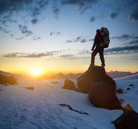 Silhouette of a tourist on the peak of high rocks. Sport and active life conceptの写真素材