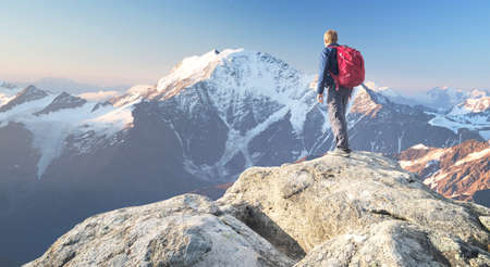 Tourist on the peak of high rocks. Sport and active life conceptの写真素材