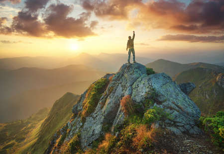 Silhouette of a champion on mountain peak. Active life conceptの写真素材