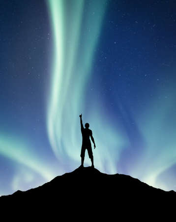 Silhouette of a winner on the northen light backgroun. Concept and idea of active lifeの写真素材
