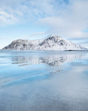 Mountain ridge and reflection on the seashore. Natural landscape in the Norwayの写真素材