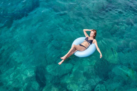 Girl relax on the sea. Beautiful girl as a concept and idea of relax timeの写真素材
