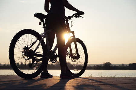 Silhouette of a girl near sea on the bike. Sport and active life conceptの写真素材