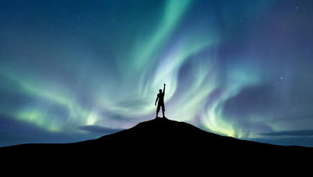 Silhouette of a championat the northen light background. Sport and active life concept and idea of successの写真素材
