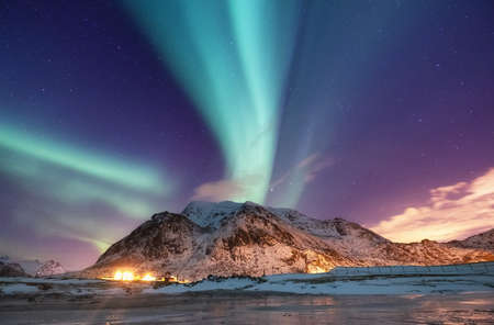 Aurora borealis on the Lofoten islands, Norway. Green northern lights above mountains. Night sky...