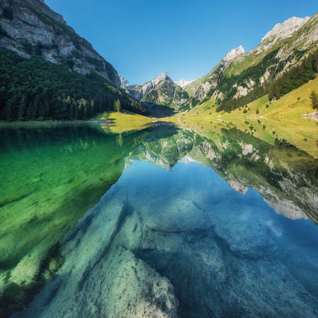 Mountains and lake in the Switzerland. Reflection on the water surface. Natural landscape in the Switzerland at the summer time. Lake and waveの写真素材