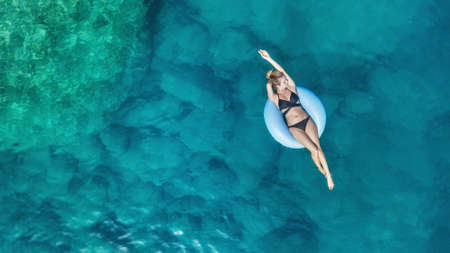 Aerial view at the girl on sea. Turquoise water from air as a background from air. Natural seascape...