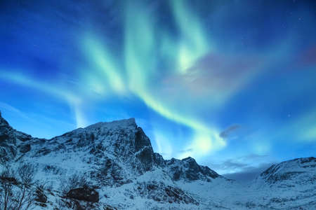 Aurora borealis on the Lofoten islands, Norway. Green northern lights above mountains. Night sky with polar lights. Night winter landscape with aurora. Natural background in the Norwayの写真素材
