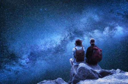 Travelers couple look at the stars. Travel and active life concept with team. Adventure and travel in the mountains regionの写真素材
