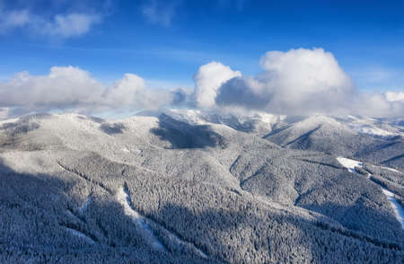 Aerial view at the slope on ski resort. Forest and ski slope from air. Winter landscape from a drone. Snowy landscape on the ski resort. Aerial photographyの写真素材