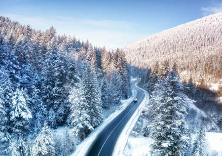 Aerial view on the road and forest at the winter time. Natural winter landscape from air. Forest under snow a the winter time. Landscape from droneの写真素材