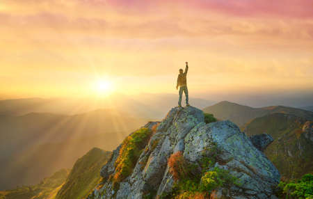 Silhouette of a champion on mountain top. Travel and adventure. Mountain hiking. Mountains during sunrise. Success and goal achievement. People success-imageの写真素材