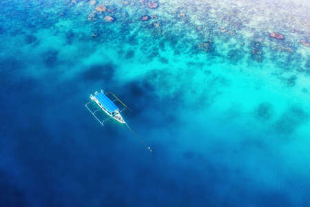 Boat on the water surface from top view. Turquoise water background from top view. Summer seascape...