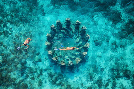 The couple snorkeling near the famous place on Gili Meno Island, Indonesia. Aerial view from drone. Underwater tourism in the ocean. Vacation and adventure. Travel - imageの写真素材