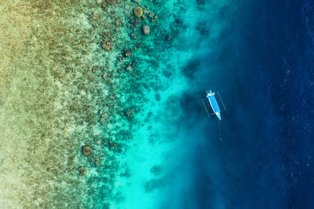 Boat on the water surface from top view. Turquoise water background from top view. Summer seascape from air. Gili Meno island, Indonesia. Travel - imageの写真素材