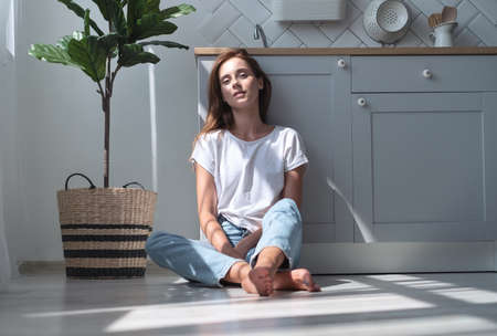 Beautiful girl resting in the kitchen. Rest and relaxation. Home interior.