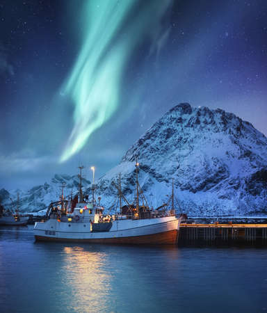 Nothen light, mountains and fishing boat. Aurora Borealis, Lofoten islands, Norway. Winter landscape at the night time. Norway - imageの写真素材