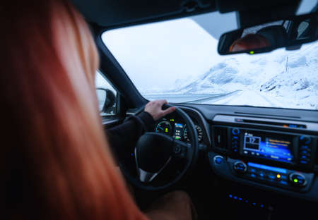 Driver at the wheel of a car. The view from inside the car on the road and landscape. Composition...