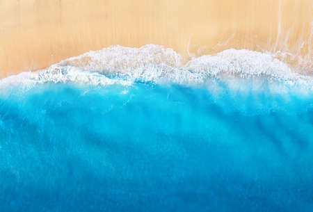 Coast with waves as a background from top view. Blue water background from drone. Summer seascape...