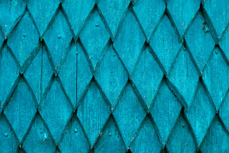 The wall of the house is made of old wood. Wooden details in the form of a rhombus. Background and texture of old painted wood.の写真素材