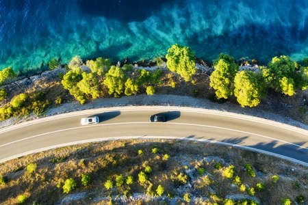 View of the road along the coast from the drone. Travel by car in summer time. The sea coast and the road. The coast of Europe.の写真素材