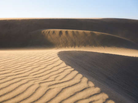 Sand dunes in the desert. Landscape in the daytime. Lines in the sand. Dunes and sky. Summer landscape in the desert. Hot weather.の写真素材