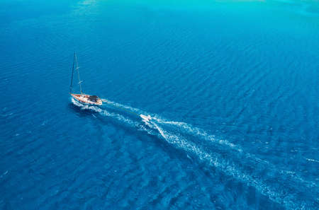 An aerial view of the yacht on the azure sea. Transparent clear water in the Mediterranean Sea....