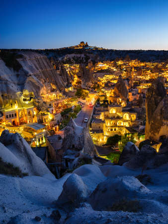 Goreme, Cappadocia, Turkey. View of the evening city from the mountain. Bright evening city and clear sky. Landscape in the summertime. UNESCO heritage. Vacation and tourism.の写真素材