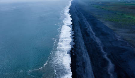 Iceland. View on the black coast line and wave. Beach and sea from high rock. Famous place in...