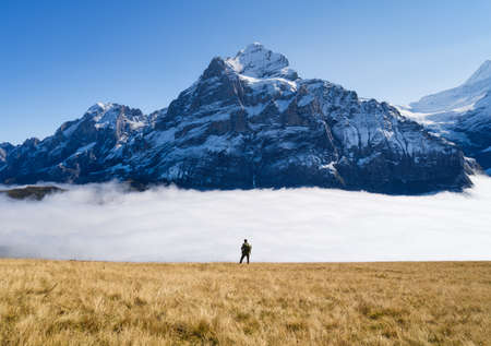 Tourist with a backpack in the mountains. Mountain hiking in the high mountains. Travel and adventure. Active life. Landscape in the summertime. Photo with high resolution.の写真素材