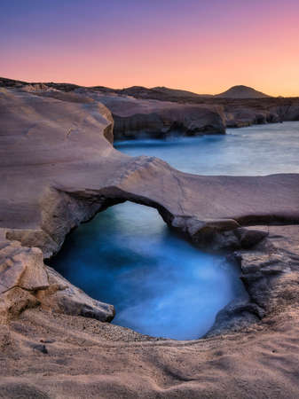 Sarakiniko beach. Milos island. Greece. A seascape during sunset. Long exposure. Rocks on the seashore. Sunlight during sunset. Natural background.の写真素材