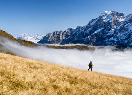 Tourist with a backpack in the mountains. Mountain hiking in the high mountains. Travel and adventure. Active life. Landscape in the summertime. Photo with high resolution.の写真素材