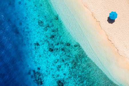 Umbrella on the beach. Beach and sand background from top view. Aerial seascape. Summer seascape from air.の写真素材