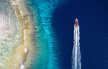 Fast boat on the sea. Aerial view of luxury floating boat on blue water at sunny day. Seascape with motorboat in bay. Travel and vacation imageの写真素材